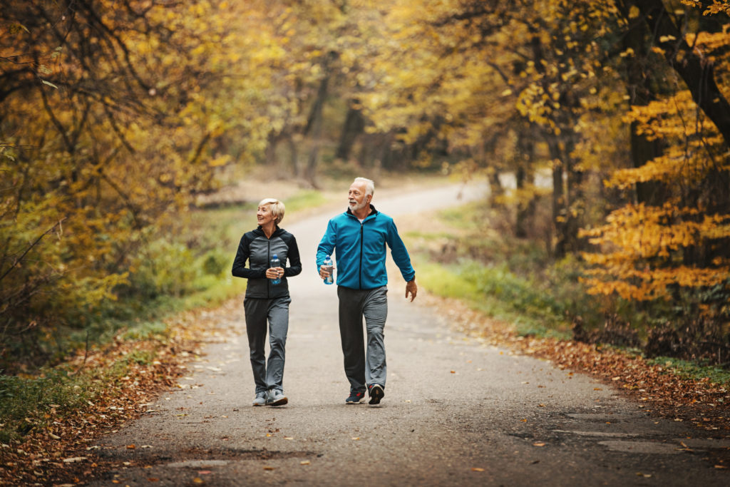 Senior couple power walking in a park. gilaxia (iStock)